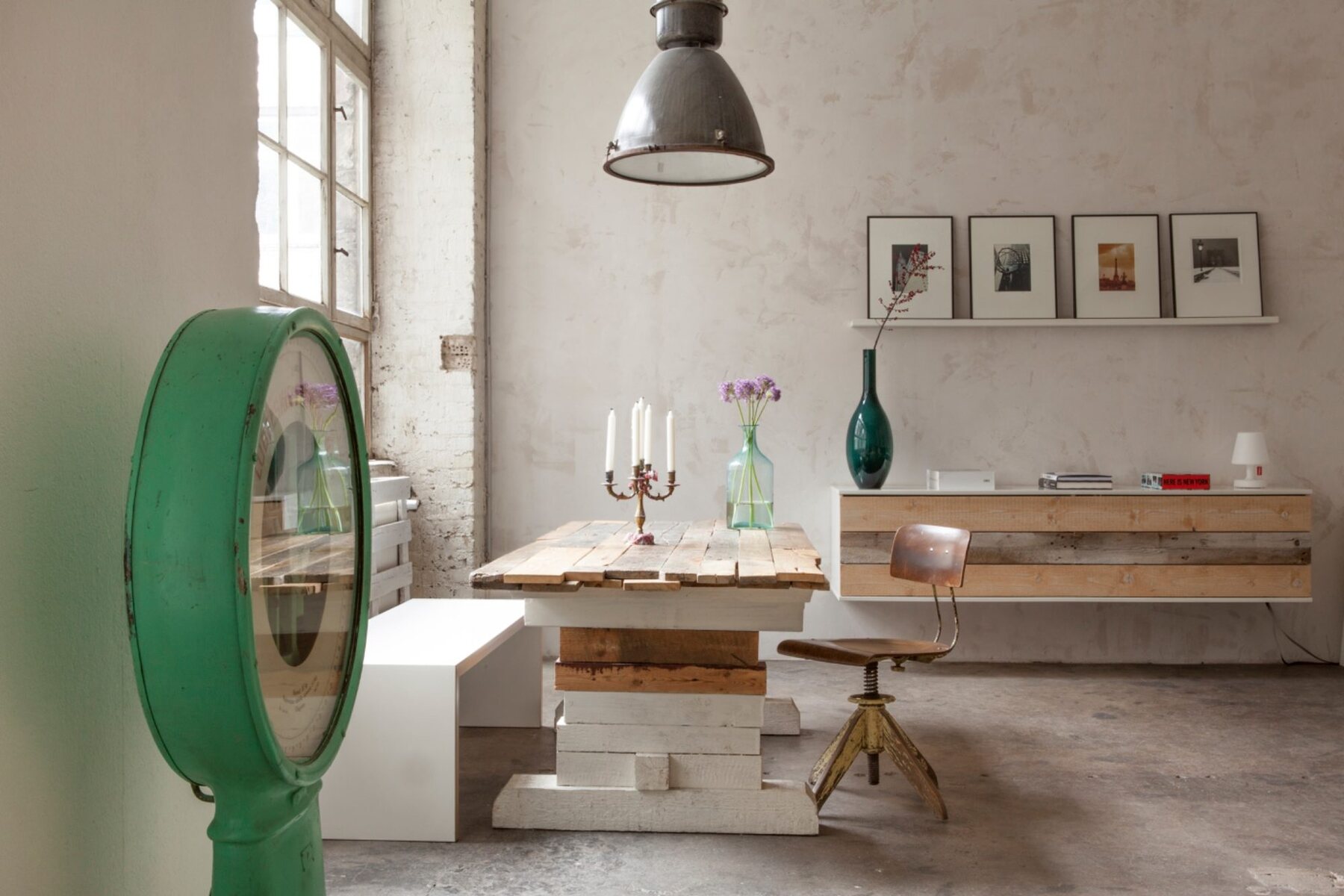 Loft mit langem Holztisch, Fabrikleuchte und Sprossenfenster